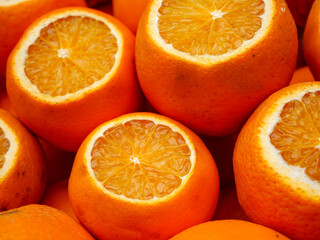 A close up of bright oranges with some sliced in half showing their vibrant pulp a beautiful and...