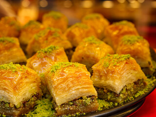 Freshly made pistachio baklava is served on a large tray its golden layers and green topping create an irresistible and delicious sweet treat