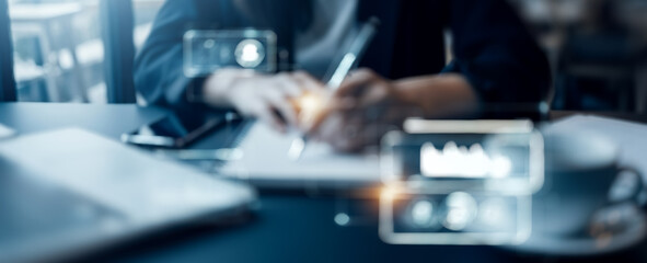 Person writing at a desk with augmented reality graphics overlayed.