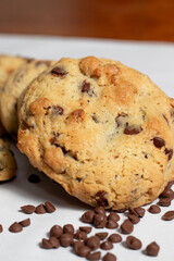 Galleta casera con chispas de chocolate sobre fondo blanco y trozos de chocolate, estilo artesanal y tentador para repostería y gastronomía.