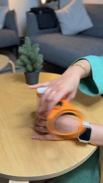 Vertical close-up of hands using an orange jar opener tool to open a kitchen container. Perfect for product ads, DIY tutorials, lifestyle tips, and e-commerce demos.