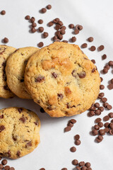 Galletas caseras con chispas de chocolate sobre fondo blanco y trozos de chocolate, estilo artesanal y tentador para repostería y gastronomía.