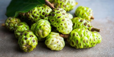 Obraz premium A close-up of fresh, ripe noni fruit, showcasing its unique texture and vibrant green color.