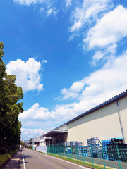 道路沿いの工場と穏やかな青空