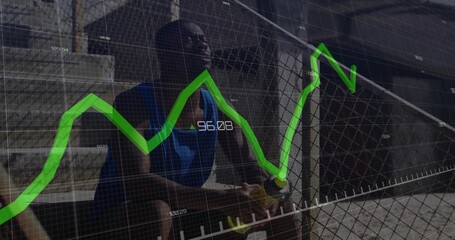Sitting athlete in sportswear holding towel by chain-link fence in urban court, green graph overlay