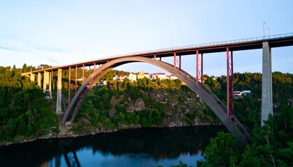 Fototapeta premium A majestic arch bridge spanning a tranquil river valley at sunrise
