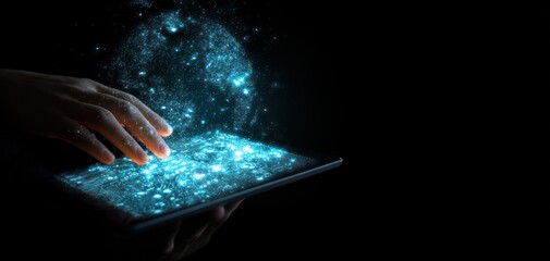 Hand interacts with a tablet displaying shimmering, cyan particles emerging into the dark, creating a captivating digital effect