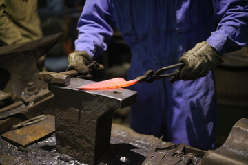 熱した材料を叩いて形を作る職人