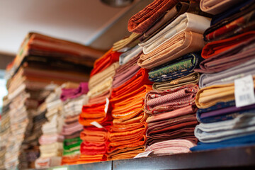 Colorful stacks of neatly folded Japanese Kimono fabric showcasing intricate patterns and vibrant designs, perfect for depicting traditional textile arts, creativity, and style.