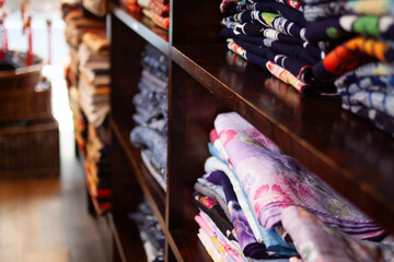 Colorful stacks of neatly folded Japanese Kimono fabric showcasing intricate patterns and vibrant designs, perfect for depicting traditional textile arts, creativity, and style.