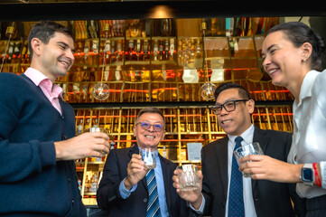 Businessmen and businesswoman drinking in night bar celebrating after successful work