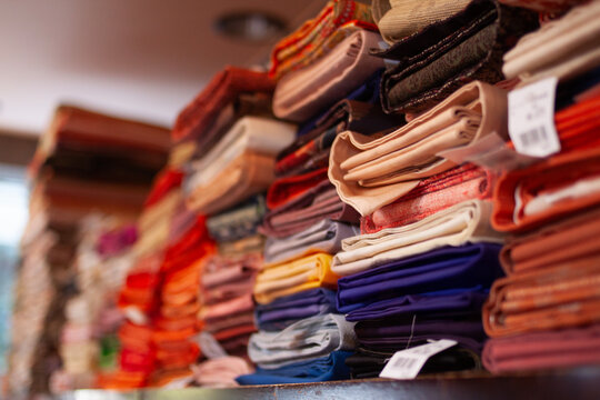 Colorful stacks of neatly folded Japanese Kimono fabric showcasing intricate patterns and vibrant designs, perfect for depicting traditional textile arts, creativity, and style.