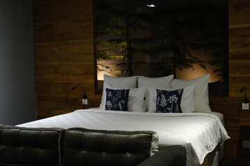 Neatly made bed with white bedding in soft night light