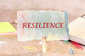 The written word RESILIENCE on a colored piece of paper in a clothespin
