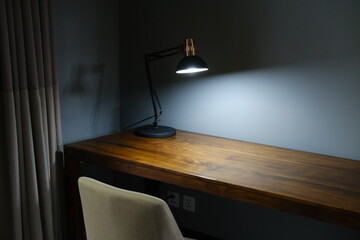 Classic table lamp glowing on wooden desk