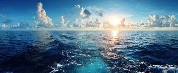 Wide panoramic view of the ocean during a sunset, with cloudy sky reflecting in the water, and the ocean surface churning