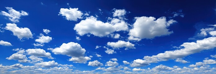 Expansive view of a bright, blue sky dotted with soft, white clouds creating a serene and airy atmosphere
