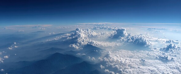 Aerial shot of mountains shrouded in ethereal mist, beneath a vast, azure sky blending into soft cloudscape horizons. Serene, tranquil, and panoramic