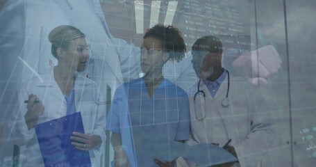 Reviewing digital charts, team in lab coats, scrubs in hospital corridor with clipboard, tablet