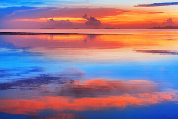 Sea beach sunset, calm ocean sunrise, beautiful peaceful tropical island landscape, idyllic seascape, colorful red orange yellow sky, golden sun reflection blue water, tranquil summer holidays, travel