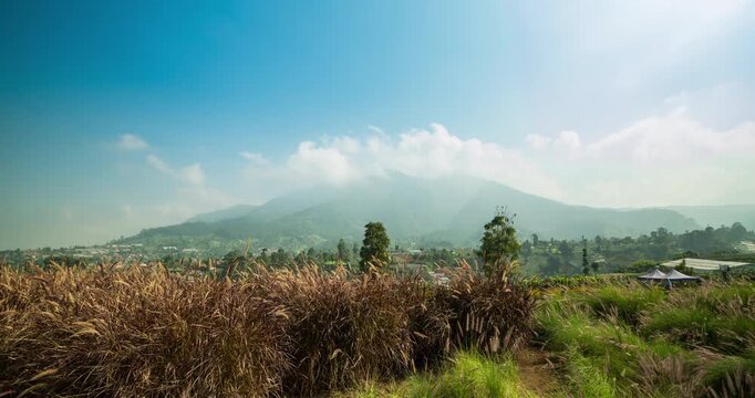 Timelapse of clouds rolling over a mountain peak on a sunny day