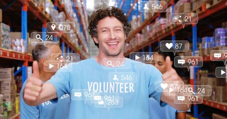Volunteers wearing light blue shirts raising thumbs up between warehouse shelves, with media icons