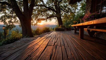 Fototapeta premium Wooden deck overlooks sunset vista, framed by trees and building's stone facade