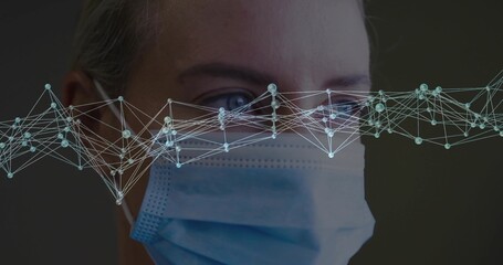 Displaying mid adult woman's face wearing surgical mask in lab, showing luminescent nodes overlay