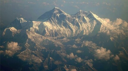 Aerial view of snow-capped mountain range.  Vast mountain peaks, clouds, and valleys