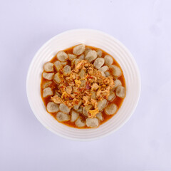 Traditional Asian Meatball Soup with Fried Onion Garnish in White Bowl