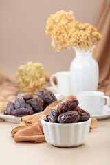 Dates in white dish on a beige background.