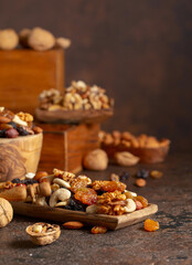 Mix of nuts and raisins on a brown rustic background.