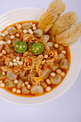 Traditional Indonesian Chicken Soup with Lime and Crispy Crackers in White Bowl
