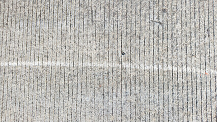 Textured concrete road surface with a single white line, useful for backgrounds and urban themes