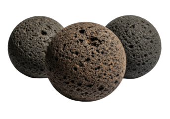 Three heavy, matte charcoal-grey volcanic rock spheres with rugged textures and earthy tones, against a transparent studio background with dramatic lighting. Concept of elemental strength