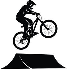 Silhouette of a mountain biker jumping over a ramp, performing extreme stunt