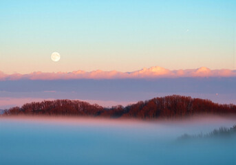 Obraz premium Moonrise over misty forest, colorful twilight sky.