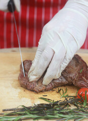 The steak is being cut with a knife.