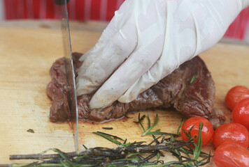 The steak is being cut with a knife.