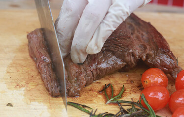 The steak is being cut with a knife.