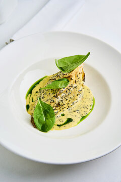 A beautifully presented dish of whole roasted celeriac is accompanied by a creamy tahini herb sauce. The vibrant tobiko adds a unique texture, enhancing the gourmet feel
