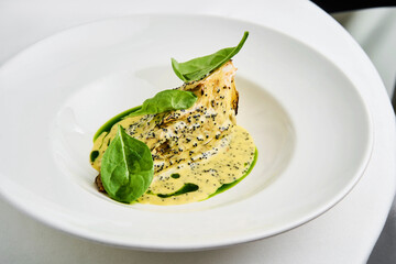 Whole roasted celeriac is plated beautifully, topped with a savory tahini herb sauce and garnished with tobiko and fresh greens. This dish showcases a blend of flavors and textures