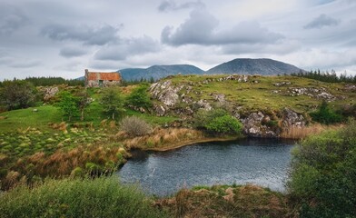 sunrise landscape scenery old rusty tin roof cottage on green hill Connemara, Ireland background