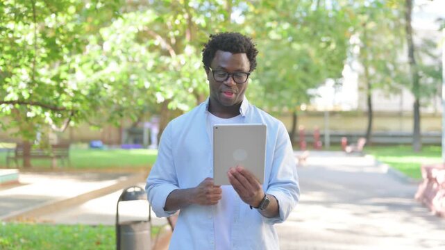 African Man Video Calling on a Tablet, Outdoor Portrait