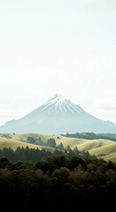 Obraz premium Mount Taranaki New Zealand Landscape Photography | Scenic Snowy Volcano and Green Rolling Hills for Travel and Tourism Advertising