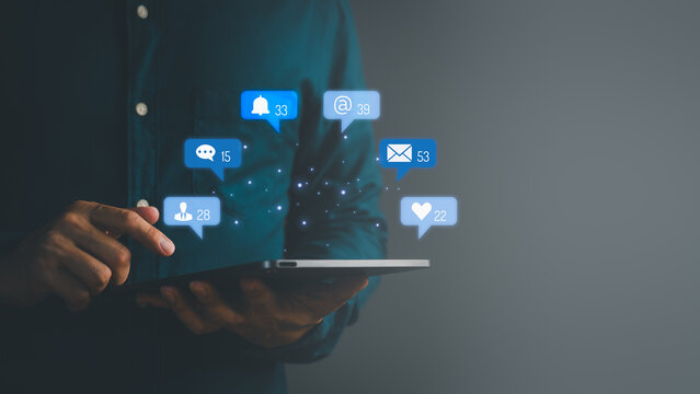 Man using digital tablet with floating social media notification icons, symbolizing online communication, messaging, email, followers, likes, and digital network connectivity.