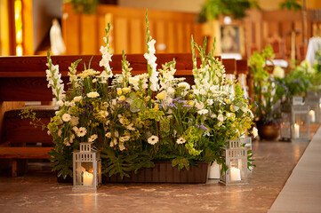 Dekoracja kwiatowa z latarniami w kościele © mydayphoto