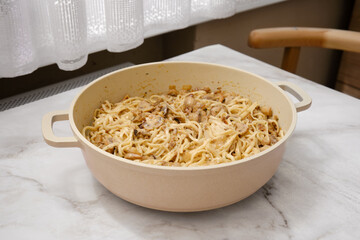 Cooking noodles with mushrooms on a kitchen table in a cozy home setting