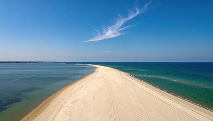 Long sand spit tapering toward horizon under thin cloud large clean sky representing coastal landscape line suitable for calm seascape and editorial design