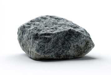 A gray, textured rock sits against a white backdrop, showing rough surface detail and casting a subtle shadow